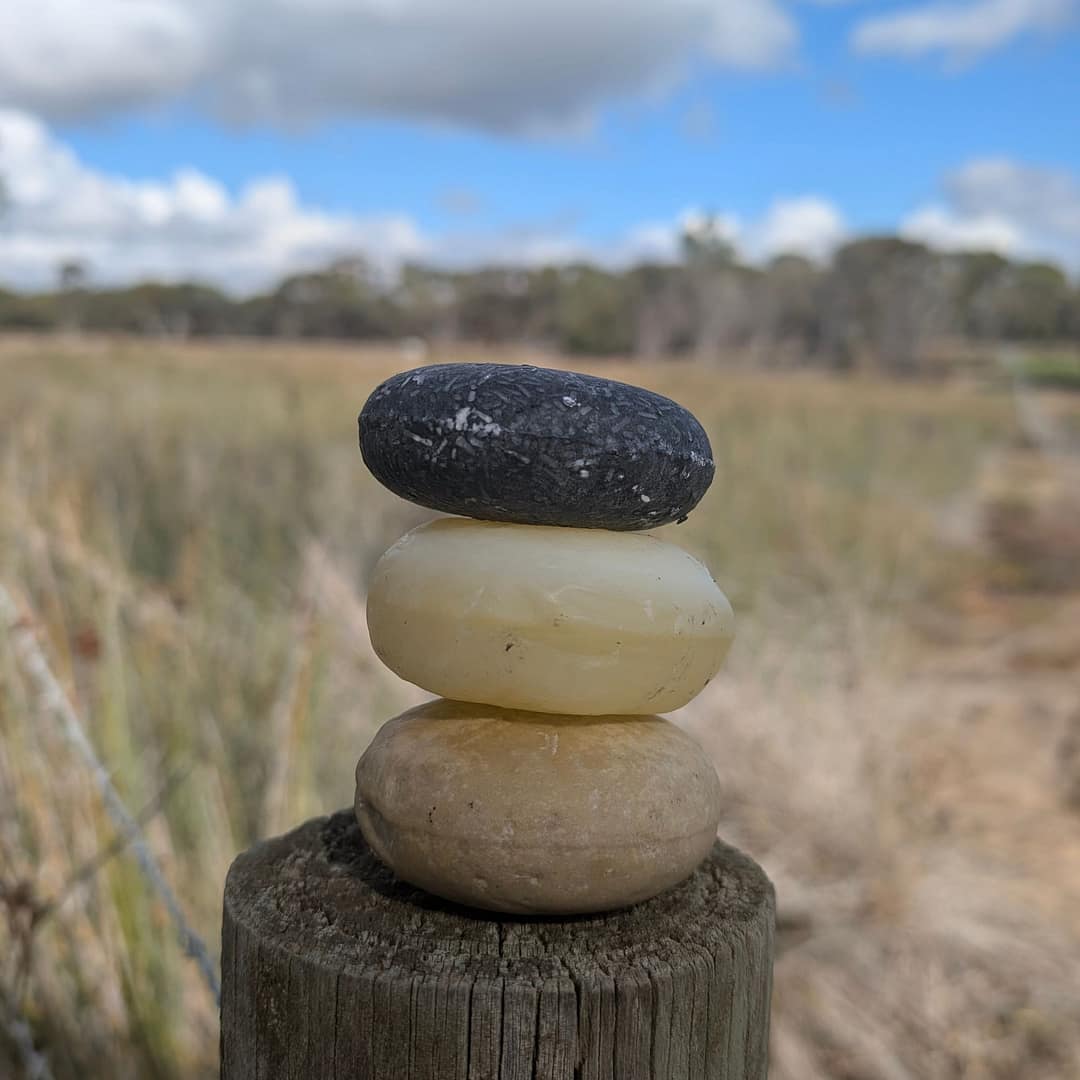 Hydrate & Detox Bar Set – Shea Butter, Charcoal & Argan Oil 1 hydrate and detox shampoo and conditioner bar set stacked on rock outdoors
