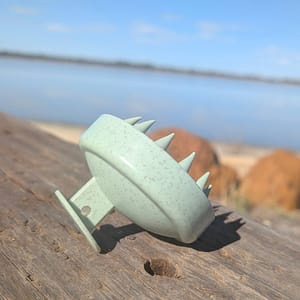 scalp massager placed on wooden surface outdoors in natural light