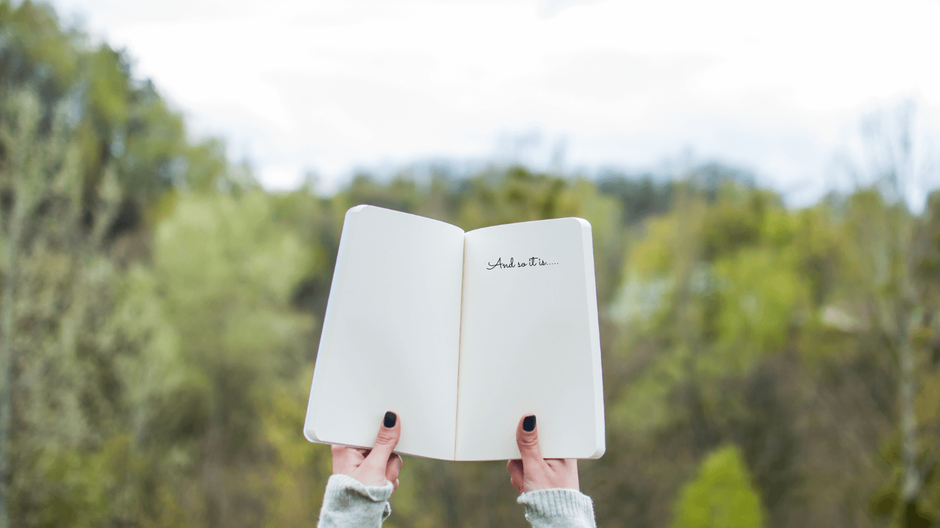 Open journal held outdoors representing professional haircare education, ritual and slow beauty